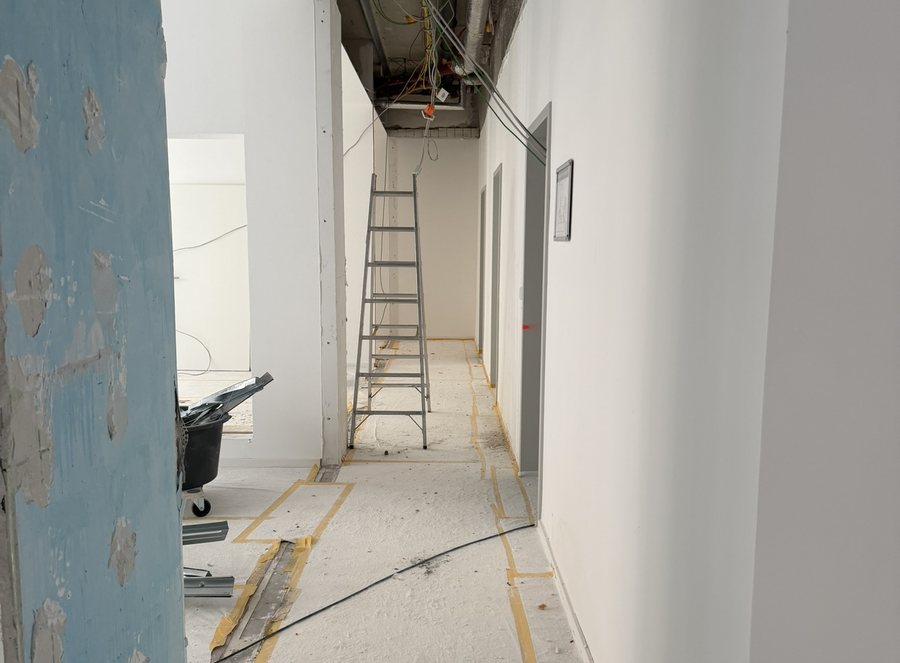 Flur nach der Entkernung mit geöffneter Decke, freigelegter Wand und Stehleiter